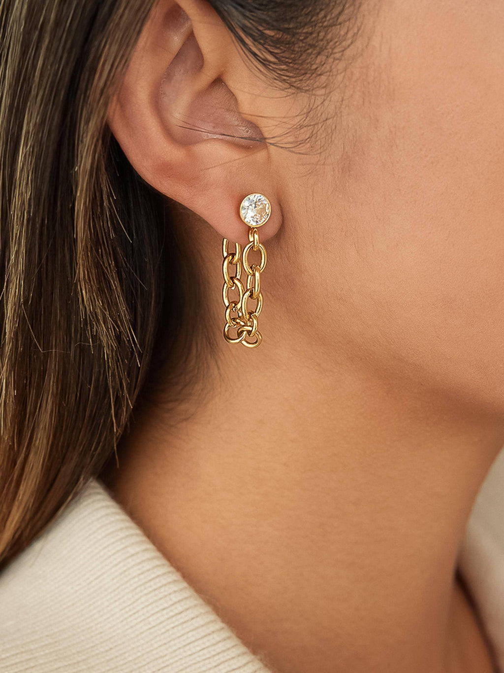 Woman wearing gold chain earring with CZ stud 