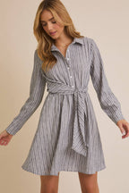Woman wearing a striped shirt dress on a beige background
