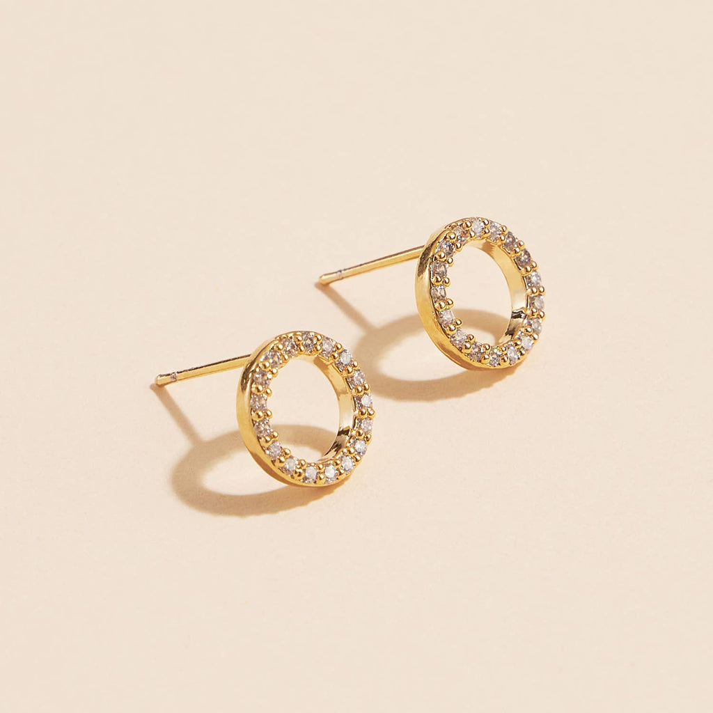 Open circle pave cubic zirconia stud earrings on a cream background