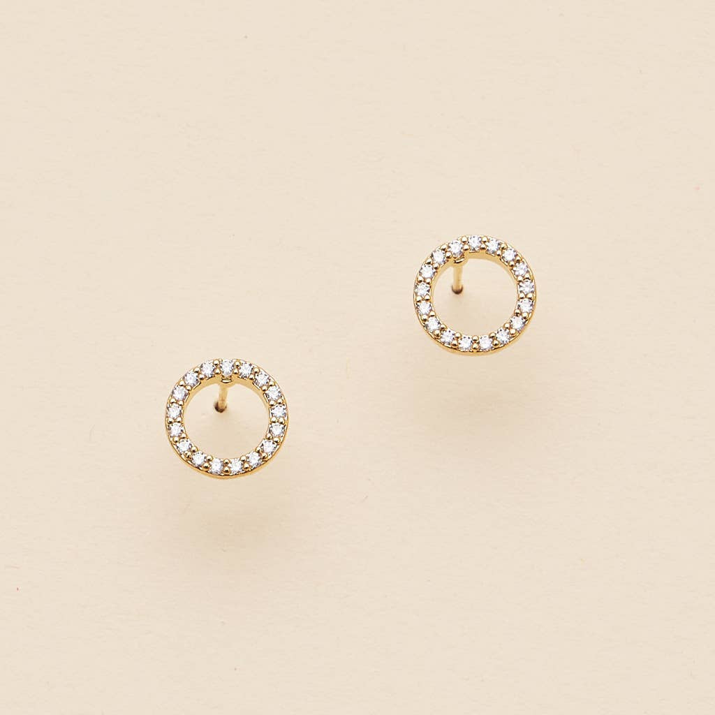 Open circle pave cubic zirconia stud earrings on a cream background
