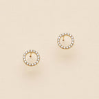 Open circle pave cubic zirconia stud earrings on a cream background