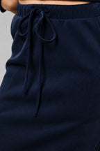 Close-up of a navy blue skirt with an elastic drawstring waistband, worn by a model.