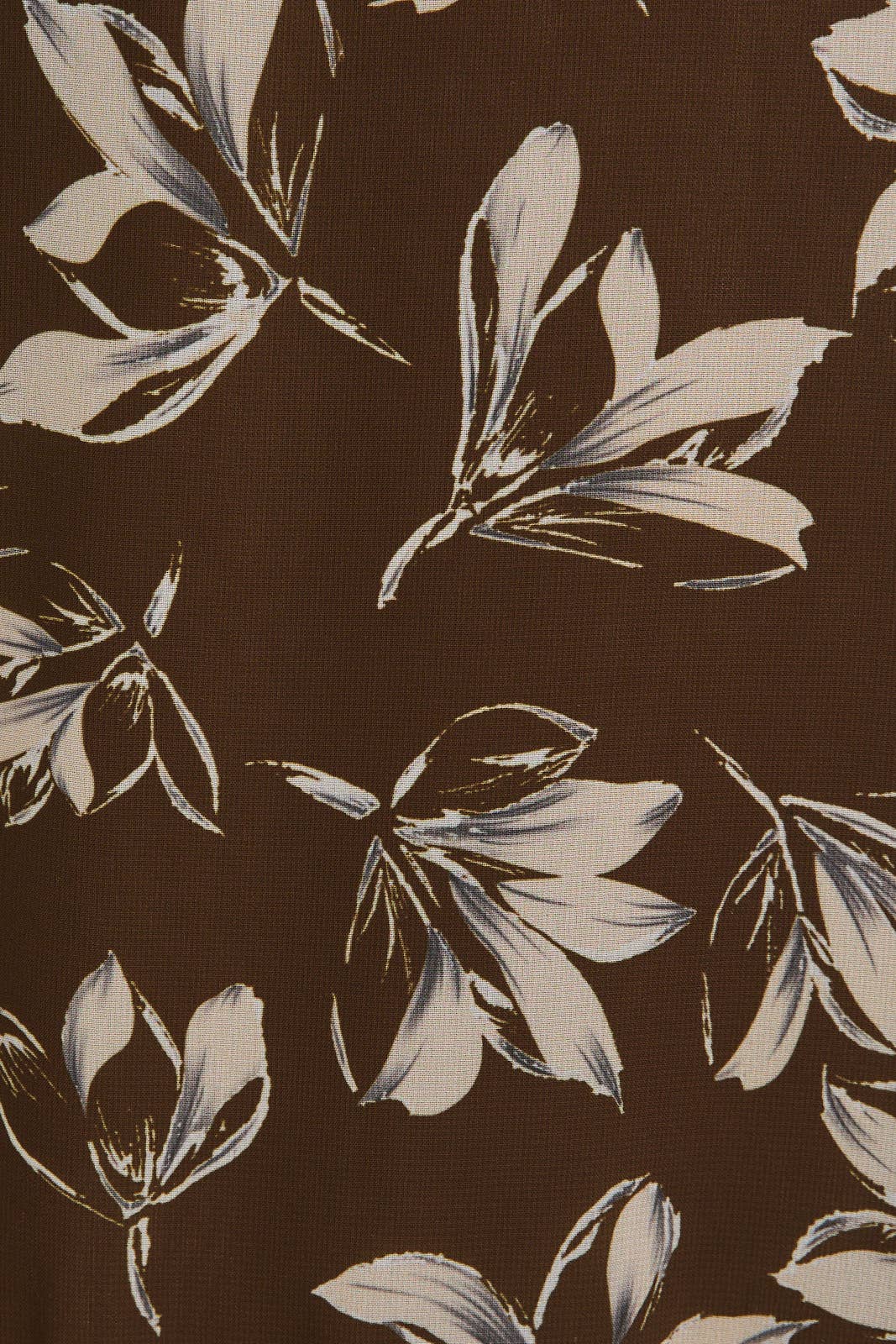 Close up of cream floral pattern on a brown background