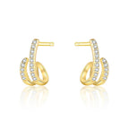 Gold-plated hoop earrings with pave CZ stones on a beige surface