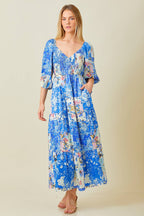 Woman wearing blue patchwork print maxi dress against grey background