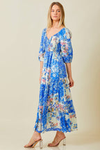 Woman wearing blue patchwork print maxi dress against grey background