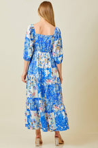 Woman wearing blue patchwork print maxi dress against grey background