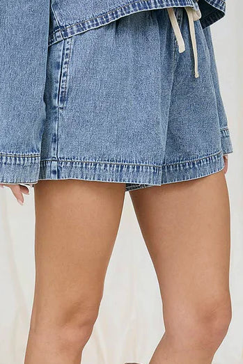 Woman wearing denim shorts and brown boots against a white background