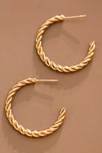 18k gold-plated stainless steel twisted hoop earrings on a brown background