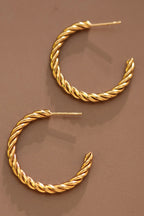 18k gold-plated stainless steel twisted hoop earrings on a brown background