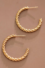 18k gold-plated stainless steel twisted hoop earrings on a brown background