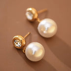 Pearl drop earrings with CZ gold stud post on a brown background