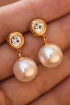 Hand holding pearl drop earrings with CZ gold stud post