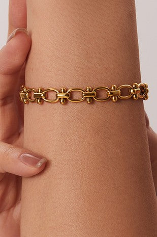 18k gold-plated chain bracelet on a wrist with a neutral background