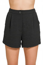 Woman wearing classic black shorts on white background