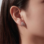 Woman wearing a pair of silver plated geometric triangle stud earrings adorned with cubic zirconia 