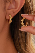 Woman wearing 18k gold-plated stainless steel floral design hoop earrings