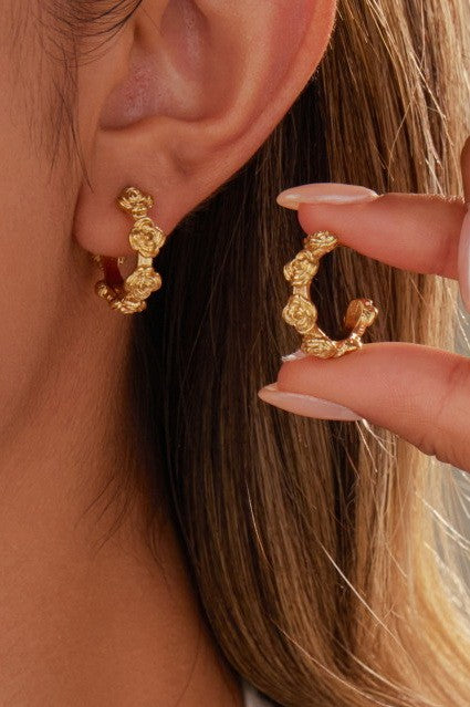 Woman wearing 18k gold-plated stainless steel floral design hoop earrings