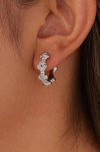 Woman wearing 18k silver-plated stainless steel floral design hoop earrings