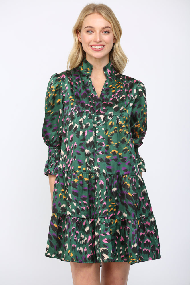 Woman wearing a green background  patterned dress on a white background