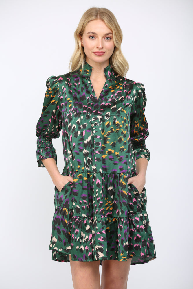 Woman wearing a green background  patterned dress on a white background