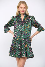 Woman wearing a green background  patterned dress on a white background