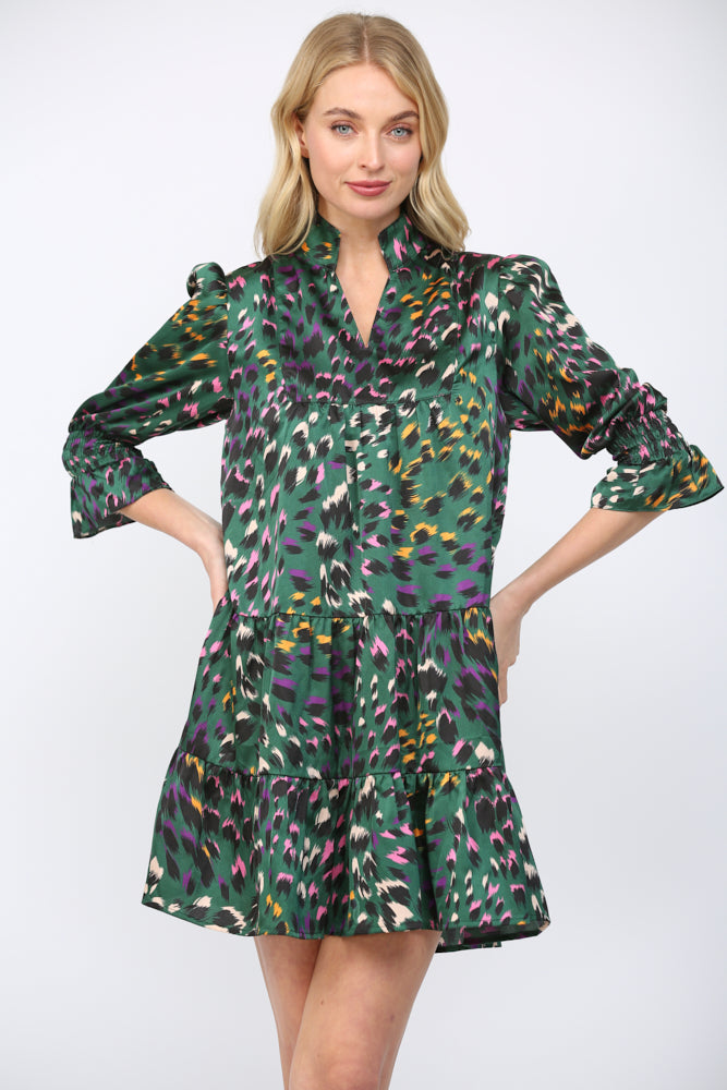 Woman wearing a green background  patterned dress on a white background