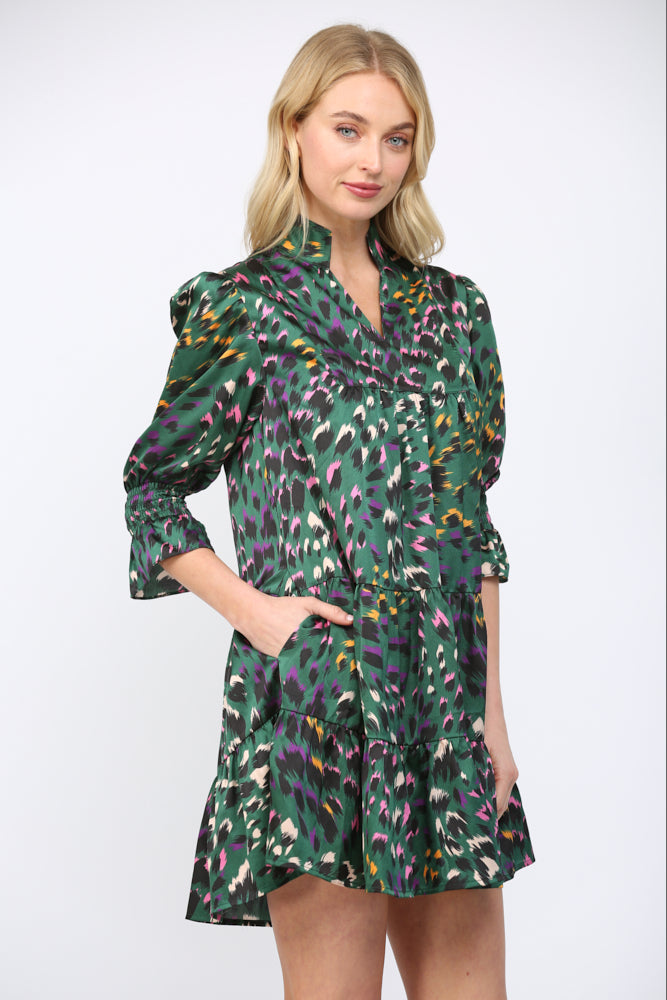 Woman wearing a green background  patterned dress on a white background