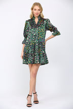 Woman wearing a green background  patterned dress on a white background