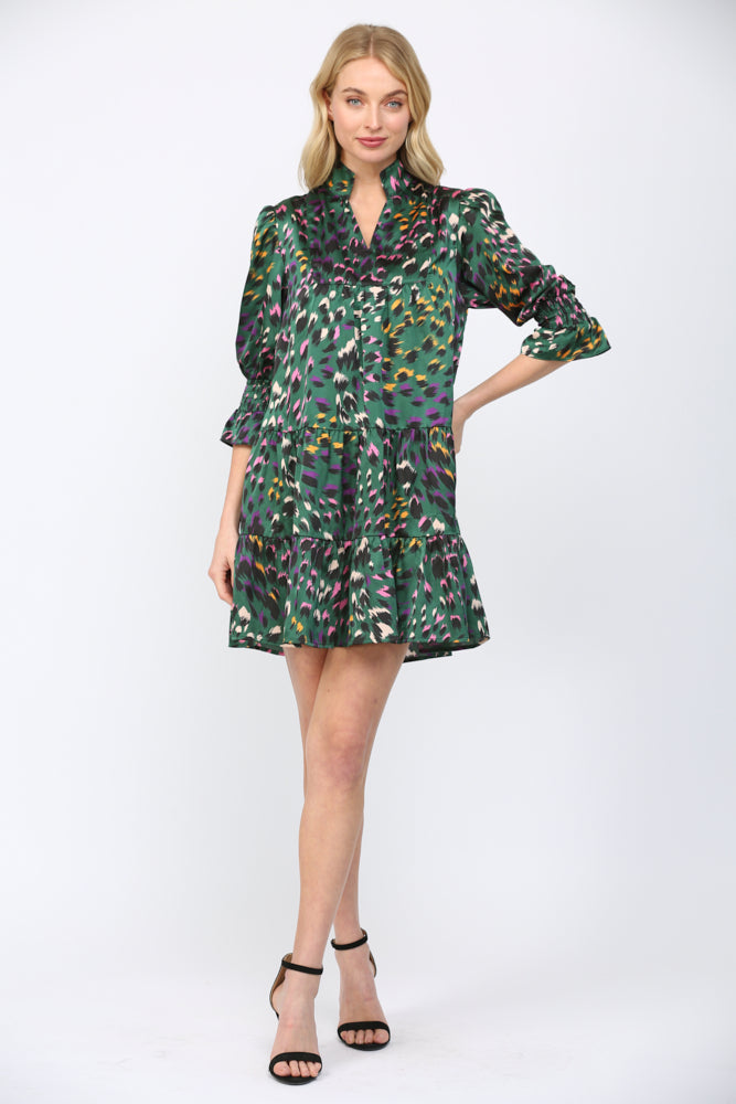 Woman wearing a green background  patterned dress on a white background