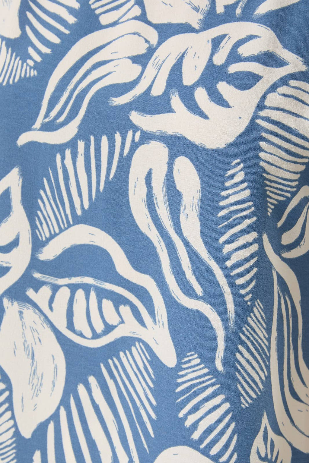 Fabric with ivory leaves on a denim blue background
