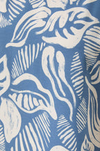 Fabric with ivory leaves on a denim blue background