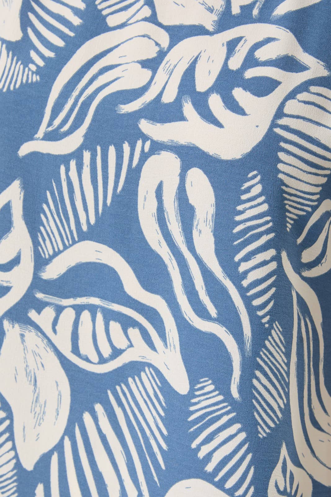 Fabric with ivory leaves on a denim blue background