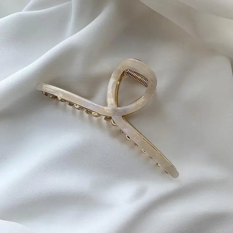 Oyster hair claw on a white fabric background