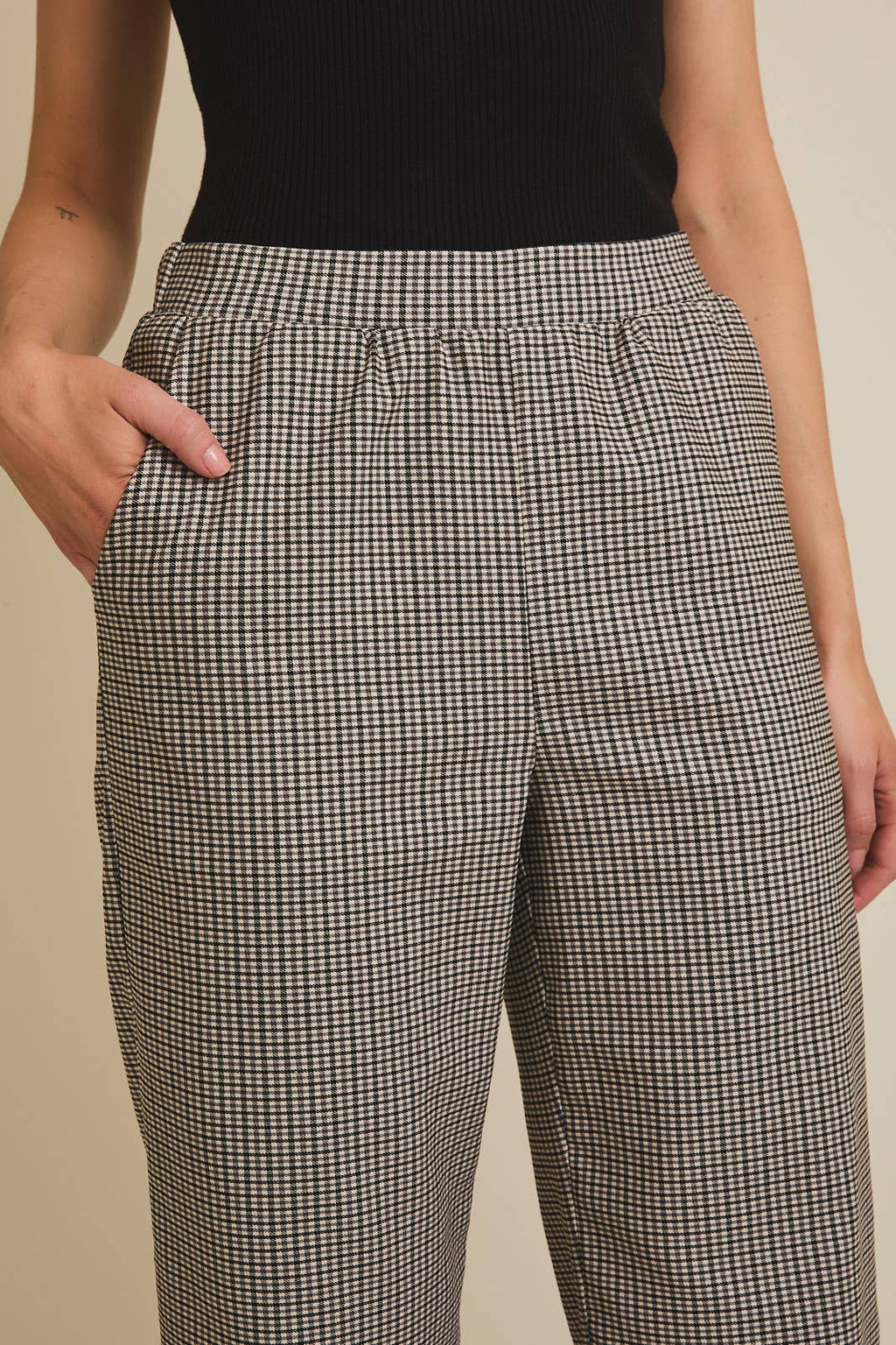 Woman wearing checkered pants with a plain background