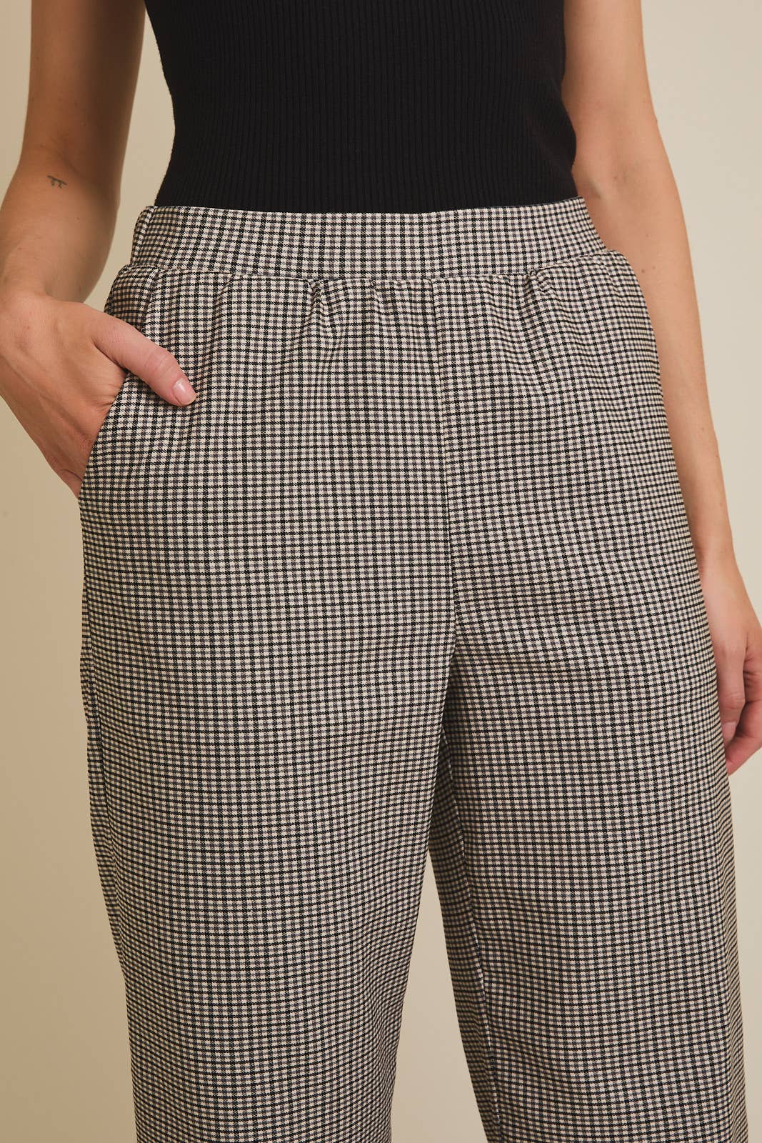 Woman wearing checkered pants with a plain background