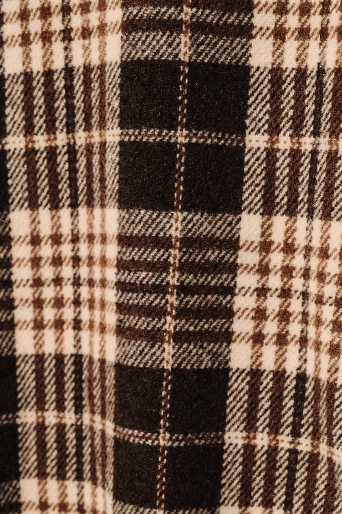 A close-up of a plaid fabric pattern with alternating vertical stripes in brown and cream.