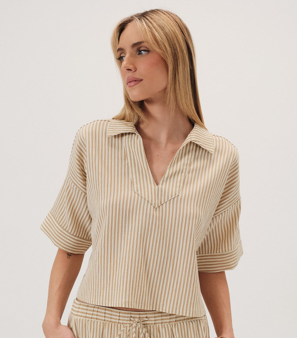 Woman wearing a beige striped top on a white background