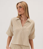 Woman wearing a beige striped top on a white background