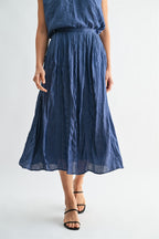 Woman wearing a dusty blue skirt on a white background