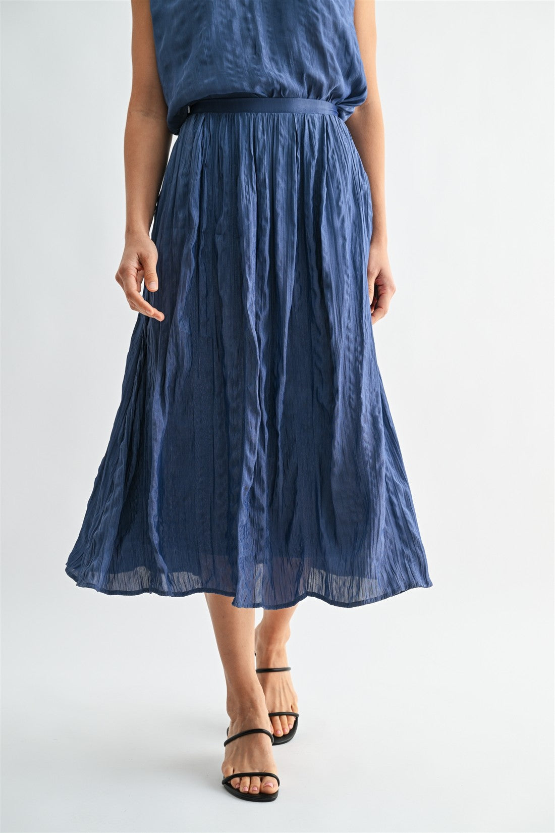 Woman wearing a dusty blue skirt on a white background