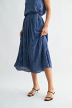 Woman wearing a dusty blue skirt on a white background