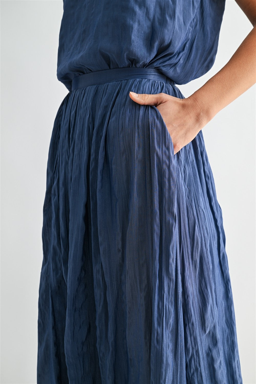 Woman wearing a dusty blue skirt on a white background