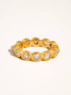A gold plated eternity-style ring with round cubic zirconia set in a repeating pattern, photographed on a clean white background.