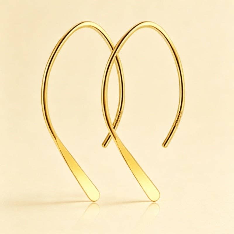 Gold plated open arch threader earrings against a beige background