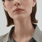 Woman wearing gold plated open arch threader earrings