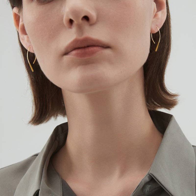 Woman wearing gold plated open arch threader earrings