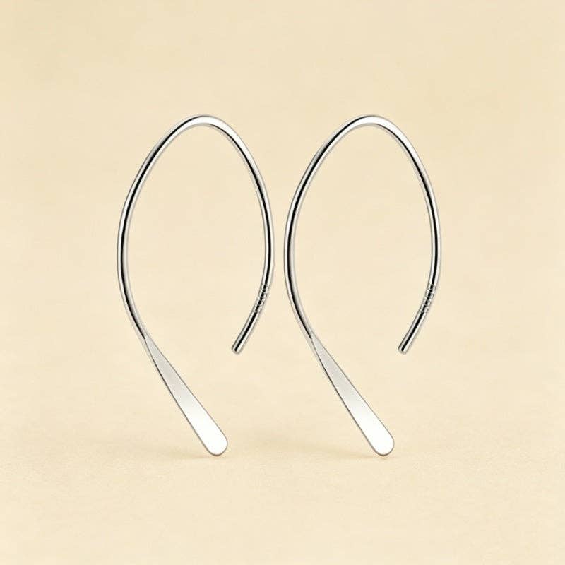 Silver plated open arch threader earrings against a beige background