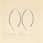 Silver plated open arch threader earrings against a beige background