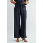 Woman wearing navy wide-leg pants on a light gray background